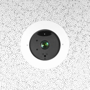 Ceiling-mounted security camera with speckled background.