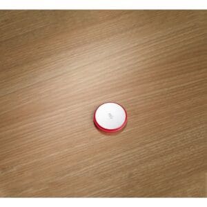 Red and white circular object on wood.