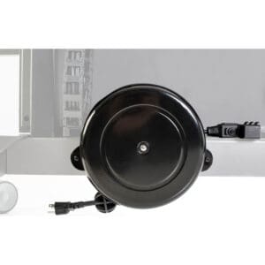 Black retractable power cord reel on wall.