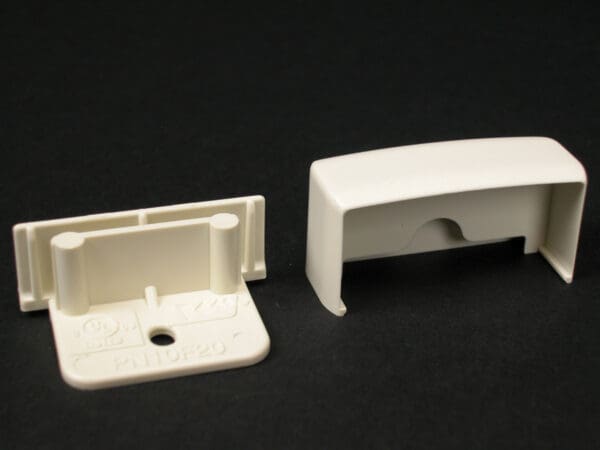 Off-white plastic window blind end caps.