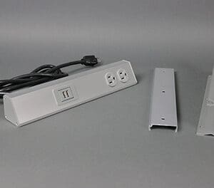 Here's an alt tag for the image: `Under-desk power strip with mounting brackets`
