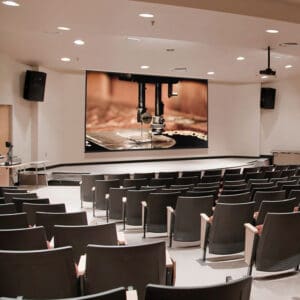 Auditorium with sewing machine projection.