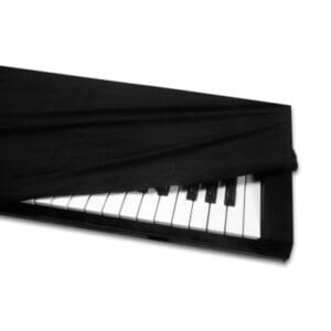 Piano partially covered with black fabric.